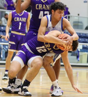 Junior Marco Garcia, white jersey, battles for a loose ball with Crane’s Keaton Sena (12). Garcia tallied four points during Thursday’s tournament-opening game for the Panthers. Photo by Shawn Yorks