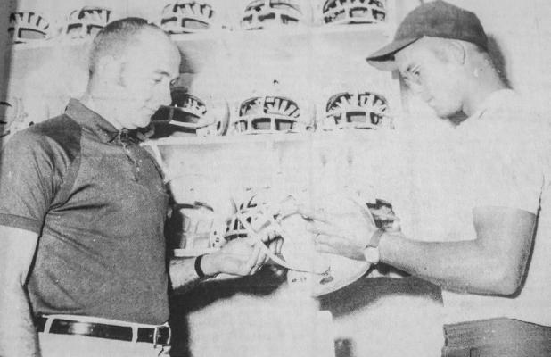 August 1971: CHECKING EQUIPMENT – James Bates, left, eighth grade football coach, and Bill Pearce, freshman football mentor, examine this new helmet as football season approaches. Shoes were checked out to footballers Wednesday, with the first day of practice planned Monday. Eighth graders will not donn their apparel until school starts August 23.