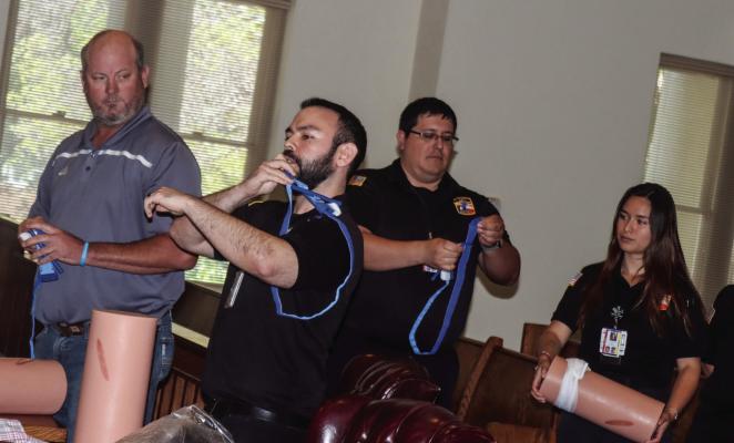 The Pecos County EMS demonstrated how to stop a traumatic bleed with Precinct 4 commissioner Nathan Reeves, left, at Monday’s County Commission meeting as part of National Stop the Bleed Day, which is May 25. Pioneer photo by Shawn Yorks