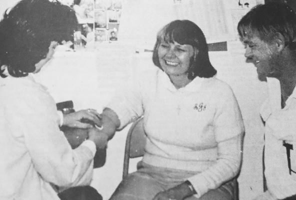 December 1983: DIABETES SCREENING – Bob Jenson lends his wife, Arleta, support as she undergoes a blood test in the Diabetes screening held at the Texas Department of Health Clinic and coordinated by the Evening Lions Club. The Jensons were just two out of 87 persons who participated in the all-day screening, headed by Judy Minter, RN and nurse coordinator with TDH, Solange Chapman, RN and Merrill Laurentz, RN of Lubbock. Results of the tests are expected in three weeks.