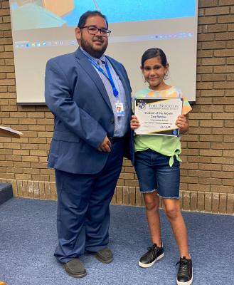 FSISD Intermediate Principal Julian Castillo presented Zoie Ramirez with her Student of the Month award.