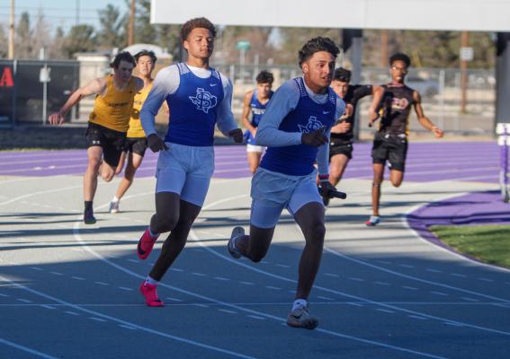 Isaiah Garcia, left, hands the baton to his cousin, Marco Garcia, during the 400-meter relay at the West of the Pecos Relays at Pecos High School on March 3. Photo by Nathan Heuer