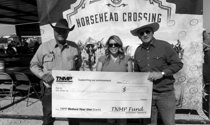 Ally Tello of TNMP presents a $5000 check to Goodnight-Loving Trail, Inc. director Ernest Woodward and Pecos County Historical Commission Secretary Kirby Warnock to install solar panels. Courtesy photo