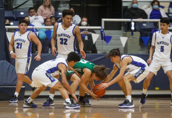 Fort Stockton seniors Shane Velasquez, left, and Caleb Garcia, right, attempt to pry the ball away from Monahans’ Trey Cox during Tuesday’s game at the Special Events Center. Photo by Nathan Heuer