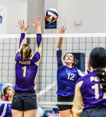 Fort Stockton’s Mia Garcia (12) knocks the ball over for one of her seven kills, Friday against Pecos. Photo by Shawn Yorks
