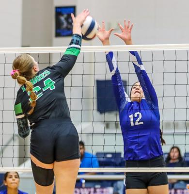 Fort Stockton sophomore middle blocker Mia Garcia (12) defends the net against Monahans sophomore middle hitter Isabella Nicholas (24) Saturday at Fort Stockton High School. The Prowlers won the first two sets of the district match but Monahans rallied to take the final three and grab the win. Photo by Shawn Yorks