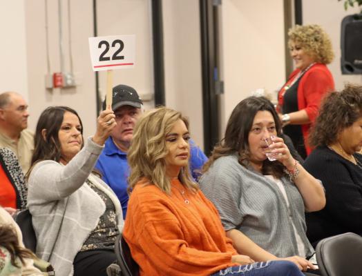 A bidder hopes for the highest bid to secure one of the holiday items at Thursday night’s Xi Zeta Lambda Sorority holiday auction. Photo by Shawn Yorks
