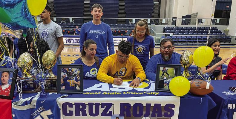 Cruz Rojas (yellow) signed a letter of intent to play football at Angelo State University on March 9 at Fort Stockton High School.