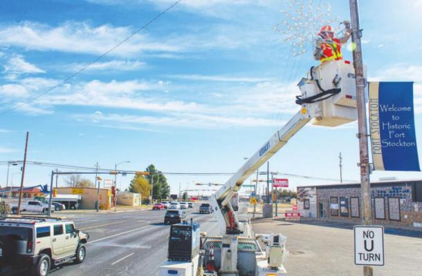 The City of Fort Stockton’s Parks Department has been busy this week removing every Christmas light and holiday flag from both stretches of Dickinson and all of Main St. The task requires immense safety precautions of both the lifted employee and oncoming traffic. Photo by Jeremy Gonzalez