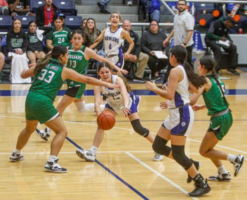 Freshman guard Victoria Maldanado, middle, completes a bounce pass to Amaya Urias under the outreached armed of Monahans’  Bethanie Sanchez (33) in the first half of Friday’s contest at the Special Events Center. Photo by Nathan Heuer