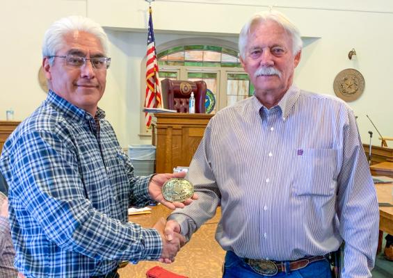 Pecos County Judge Joe Shuster presented former county commissioner Santiago Cantu with a buckle at Monday’s commissioner’s court meeting. Cantu retired as county commissioner Dec 31 after 16 years of service. Photo by Shawn Yorks