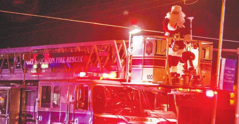 The annual Christmas Parade is a yearly festivity that people crowd around Dickinson Boulevard and Main Street to enjoy. Pictured is a local dressed as Santa in the 2020 parade. Photo by Nathan Heuer