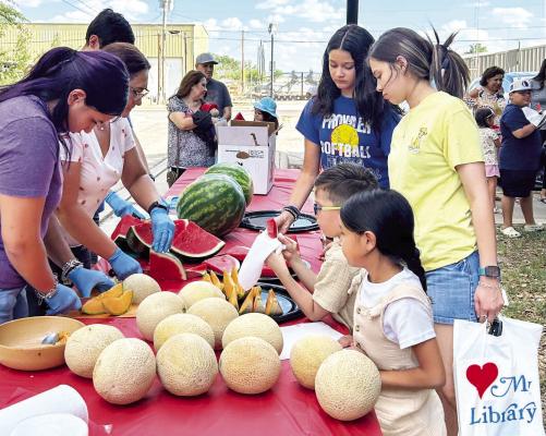After reading at the Summer Reading Program Veronica Mandujano with Mandujano Brothers Produce served watermelon and cantaloupe that she brought for the children. Courtesy Photo