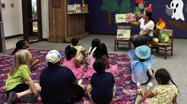 This summer the Fort Stockton Public Library has hosted a myriad of educational and child-friendly events for the community. Pictured here, Veronica Mandujano with Mandujano Brothers Produce volunteered for the Summer Reading Program. Veronica read a book and gave a presentation about produce and farming. Afterwards, she served watermelon and cantaloupe that she brought for the children. Photo courtesy of the Fort Stockton Public Library
