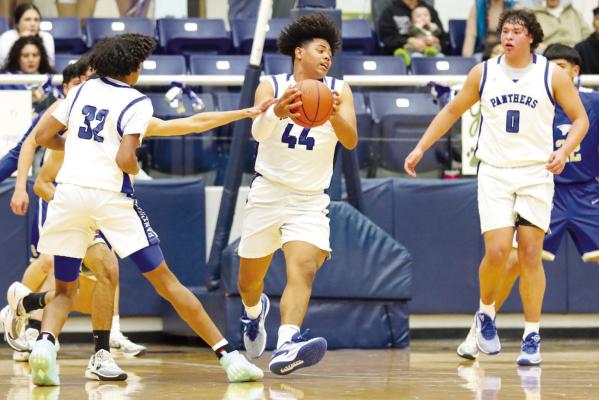 Aundre Washington (44) spins to shoot the ball as Evan Cordero (32) and Julian Leyva (0) look on, Friday against San Elizario. Photos by Shawn Yorks