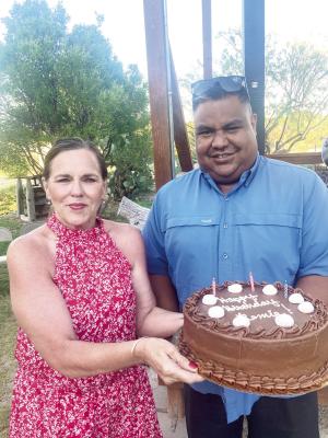 Economic Development Corporation executive director Remie Ramos, got a birthday cake from Shelli Hamilton at a recent “Summer Off the Patio” concert at the Annie Riggs Museum. The crowd joined in a singing of “Happy Birthday”. Photo by Kirby Warnock