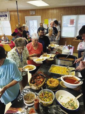 Seniors line up for dinner at a recent potluck.