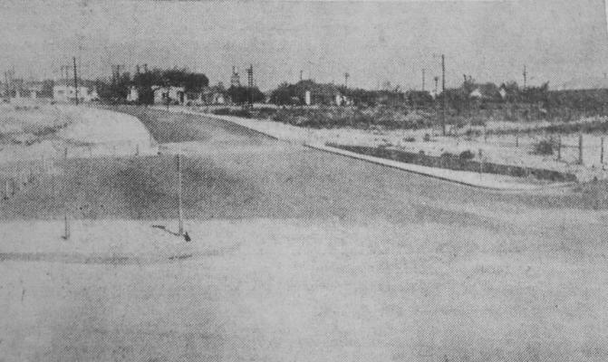 June 1955: NEW APPROACH – Pictured is the new approach to Comanche Springs Pool which will do much to aid traffic flow and help with the parking problem during the coming Fort Stockton Water Carnival June 16-17-18. East Second Street has been paved from Water Street through to Spring Drive, with a gentle dip across a once-rough dirt crossing if a dry arroyo in the center if the picture. An eroded area once a dump for trash and junk is being filled and graded in the zone at left of the paving.
