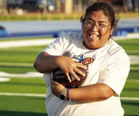 Football mom Leonela Hernandez hangs on to the football while running a drill during the Panthers’ annual Moms 101 event, where mothers of players get a firsthand look at the game. Photo by Tristian Barragan