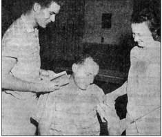October 1959: FIRST AIDERS – Bill Sallee plays guinea pig as Mrs. Lynn Falkner demonstrates the proper way to bandage an arm during Red Cross-approved first aid classes. George Fielding checks a manual to make sure.