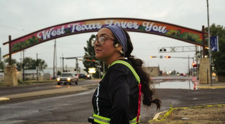 Emilie Feyry Natividad stands beneath the “West Texas Loves You” arch near Paisano Pete, watching the horizon as she waits for fellow LoneRunners to return—reminding Fort Stockton that every step forward begins with showing up.