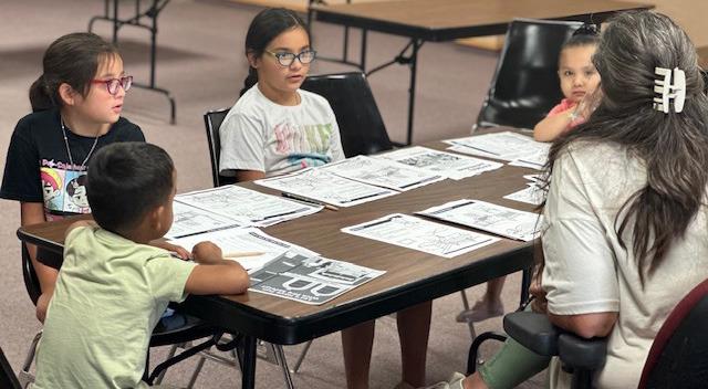 Local students engage in interactive fire safety activities during Rebecca Miller’s Safety Class, teaching fire prevention, emergency escape routes, and first-aid basics while encouraging questions and discussion.