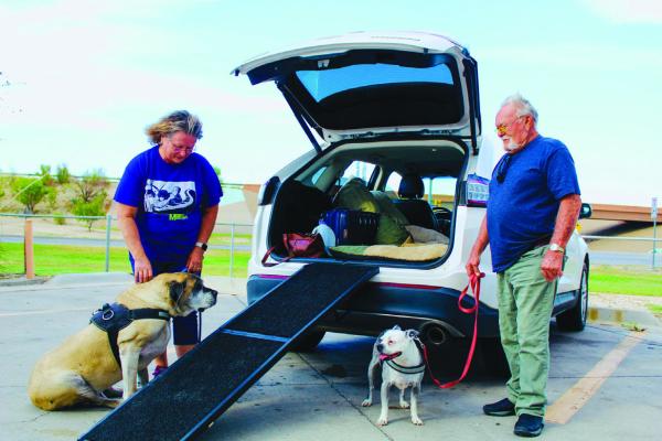 Traveler Ginny (left) prepares Ruger to crawl up the dog ramp as her husband Buck (right) holds onto their other pooch Lucille. Photo by Jeremy Gonzalez