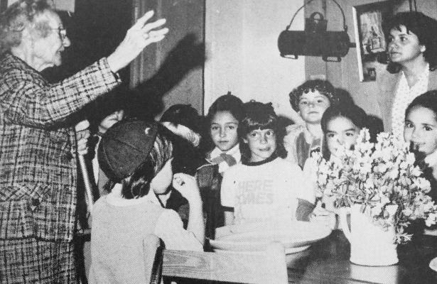 December 1983: THIS IS THE WAY IT WAS DONE – Brownie Troop members and one of their leaders, Mrs. Jamie Mitchell, listen intently as Mrs. A.W. Dunn, left, tells them about an antique “Wagon Churn” hanging over a table at Annie Riggs Museum. The girls have been studying “Women in History” and toured the museum with Mrs. Dunn Tuesday afternoon. Mrs. Jimmy Wofford is the other leader of the group.