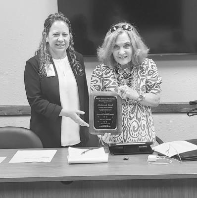 Following the session, CEO Betsy Briscoe, pictured here with longserving Director Deborah “Debbie” Teich, and Board President Matt Tarpley and other officials gathered to thank her for her years of service to the district, noting that her commitment to the board was “truly appreciated.” Teich has been a fixture on the board, participating in critical decisions regarding the hospital’s governance and leadership throughout her tenure. Photo by Joh Covington