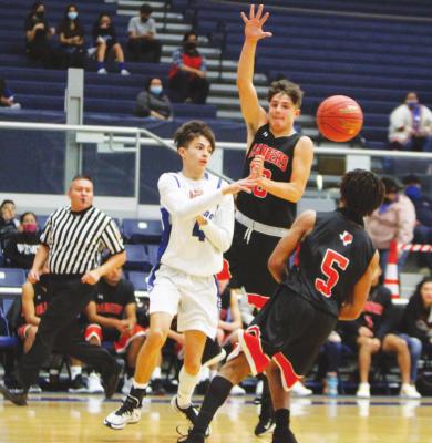 Fort Stockton’s Caleb Garcia (4) passes the ball between a pair of McCamey defenders on Tuesday, Dec. 5 at the Special Events Center. (Photo by Nathan Heuer)