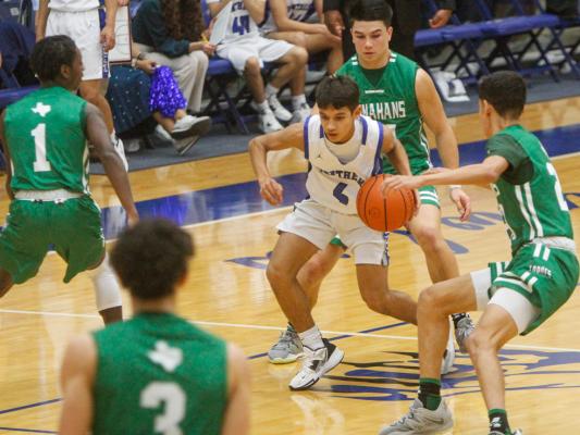 Freshman Diego Ronquillo, middle, drives through a Monahans triple team on Feb. 3 at the Special Events Center. Photos by Nathan Heuer