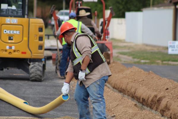 Gas Department employee Omar Salmon helps line up poly pipe as the city moves closer to eliminating all aging cast iron pipelines. Photo by Jeremy Gonzalez
