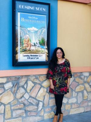 Melba Montoya enjoys her new role of marketing, sales and event coordination for the City of Fort Stockton. Standing next to the Homeward Bound poster, the movie is one of her hand-picked favorites and will be playing at the City Convention Center theater Tuesday, Nov. 23 at 3:30 and 7 p.m. Photo by Jeremy Gonzalez.