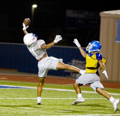 Isaiah Garcia, left, stretches for a catch past a defender during an 11-on-11 practice session.
