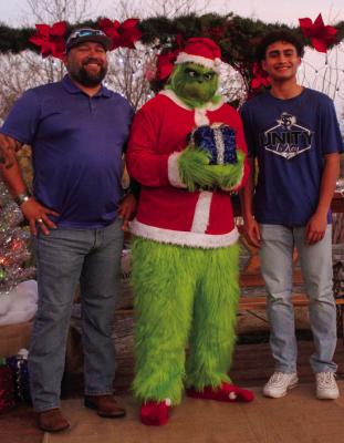 The Fort Stockton Historical Society put on the Annie’s Christmas Welcome at the Annie Riggs Museum on Dec. 2. Guests were able to take pictures with the grinch and enjoy food, beverages, and games for the youth in attendance. Pictured is Michael Pules, left, with his son Liam Pules, right, on the museum’s back porch pavilion. Photo by Nathan Heuer
