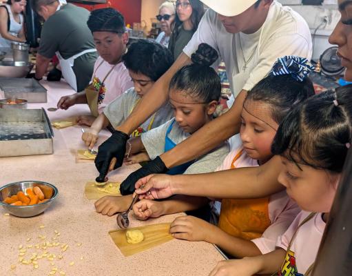 Alamo elementary learning to make tamales at barrio fest