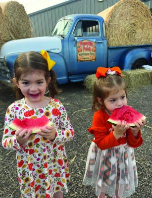Emiliana and Victoria Rodriguez enjoy sweet watermelon from the Mandujano Brothers’ Produce Farms at the 6th Annual Pumpkin Patch 5K. Courtesy Photo by Veronica Mandujano