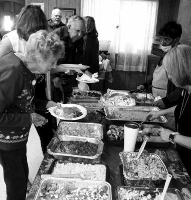 Members line up at the Senior Center for a previous potluck luncheon. Courtesy Photo