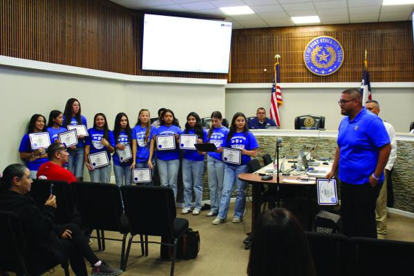 Surrounded by their families, the 8th Grade Girls Basketball Blue Team members each received a certificate to their excellent season. Photo by Joh Covington