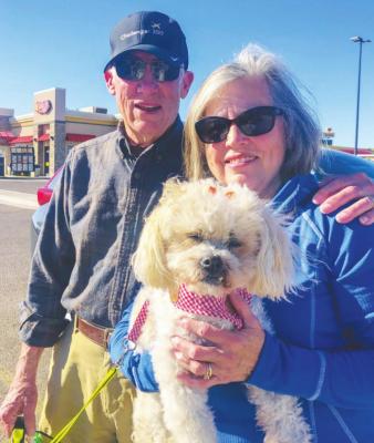 Claire wraps his arm around his wife Bonnie as she pampers their Bichon Shih Tzu mix Bella. Photo by Jeremy Gonzalez