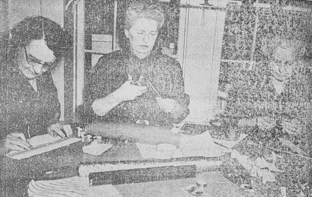 NOVEMBER 1957-CHRISTMAS DECORATIONS- for an oldfashioned tree for Holiday Hotel are being made here by, from left, Mrs. M.C. Puckett, Mrs. C.C. Pollard and Mrs. Marsh Lea. This committee is in charge of decorations for the two Pioneer Club rooms in Riggs Museum, which is being transformed by Garden Club members Dec.7 and 8 into Holiday Hotel for the public.