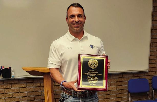 At a recent school board meeting, Athletic Director Jeremy Hickman (pictured) holds the Outstanding Sportsmanship Award earned for the district’s unwavering commitment to character, integrity, and sportsmanship across all UIL and extracurricular activities. Photo by Joh Covington