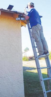 Fort Stockton Rotary Club member Anthony May installs security lights and video security cameras at El Buen Viceno. Courtesy Photos