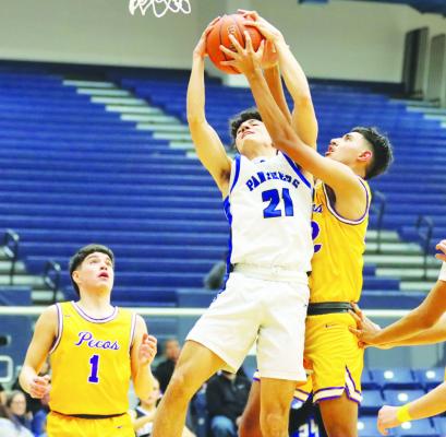 Christian Soto (21) grabs a rebound, Friday night against Pecos. Photo by Shawn Yorks