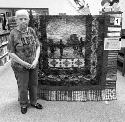 Wanda McGovern stands by her quilted creation at the Fort Stockton Public Library quilt show. McGovern’s quilt won this year’s “Best of Show” by votes from attendees.
