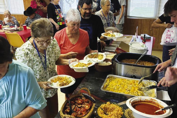 Seniors line up for dinner at a recent potluck.