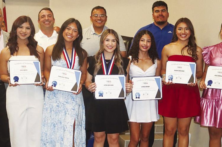 Fort Stockton Mayor Paul Casias, left, honored the Fort Stockton High School Powerlifting team and coaches at the March 25 council meeting. The girls placed sixth overall at the state meet, Belle Urbano placed fifth individually, and Jasmin Hernandez was the state champion in the 97-pound weight class. Photo by Shawn Yorks